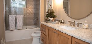 Bathroom with glass shower door, wooden cabinets and quartz vanity countertop