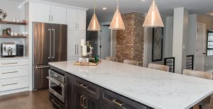 Updated kitchen with white cabinets and large center island with white marble countertops