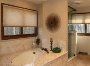 Modern bathroom with walk-in shower, granite countertops, and wood accents