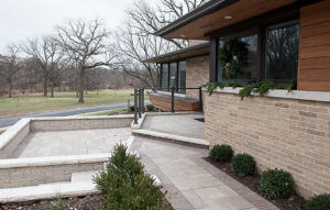 Front of a modern home with wood siding and decorative stone front walkway