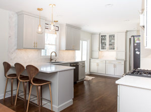 Modern white kitchen with sliding door and lots of cabinets and countertop space