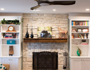 Stone fireplace with white bookshelves on either side